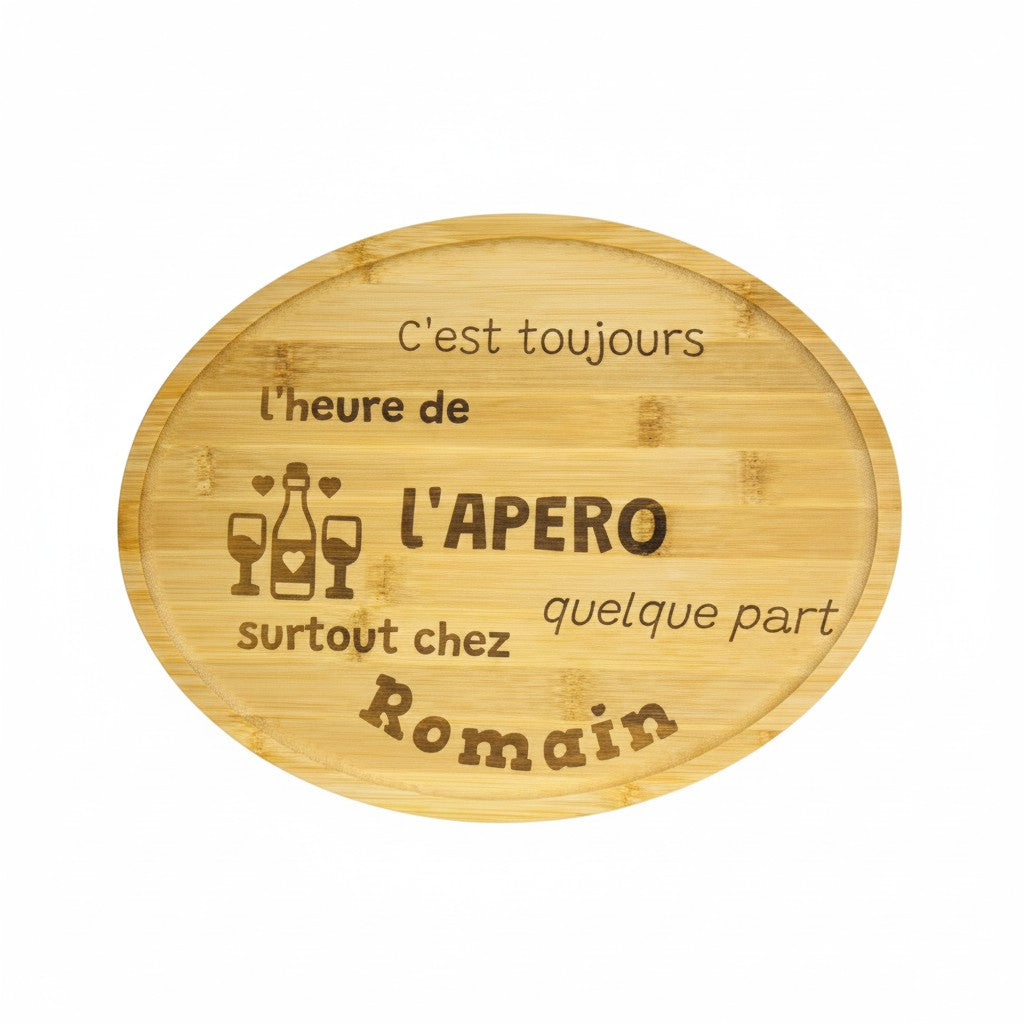 Plateau rond en bambou gravé L'Atelier de Lylou, idéal pour l'apéro, avec le texte "C'est toujours l'heure de l'apéro, surtout chez Romain quelque part".