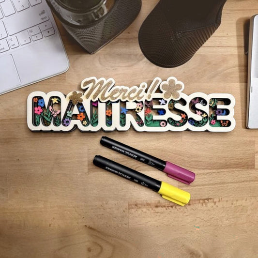Décoration murale en bois L'Atelier de Lylou "Merci Maitresse" avec motif floral coloré et texte en relief.