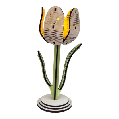 Lampe tulipe L'Atelier de Lylou en bois naturel découpé, avec des détails verts et une lumière jaune douce.