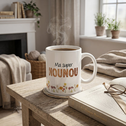 Mug blanc L'Atelier de Lylou avec l'inscription "Ma super NOUNOU" et un motif floral coloré. Cadeau personnalisé pour ATSEM, maîtresse ou nounou.
